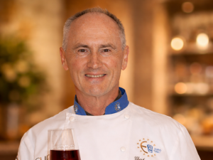 Eberhard Schell präsentiert eine dunkle Schokolade mit einem Glas Rotwein